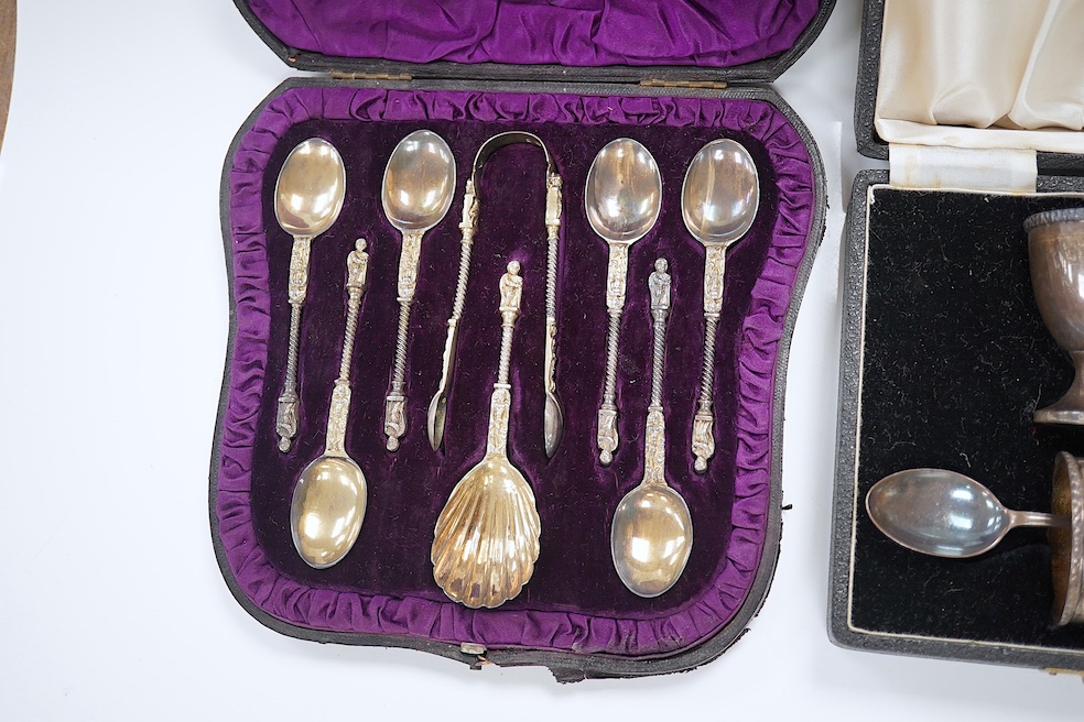 A cased set of six Victorian silver apostle teaspoons, tongs and caddy spoon, 1882, 3.7oz, and a cased George VI silver christening set comprising egg cup, napkin and spoon, 2.6oz. Condition - good.